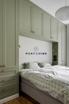 a bedroom with green cabinets and a white bed