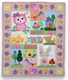 a quilted wall hanging with an owl, rabbit and other animals on it's side