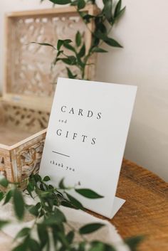 cards and gifts sitting on top of a wooden table next to a potted plant