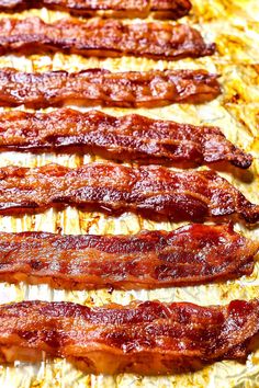 bacon strips lined up in rows on top of parchment paper and ready to be cooked