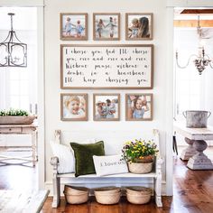 a living room with pictures on the wall and flowers in baskets sitting on the bench