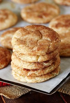 a stack of cinnamon sugar cookies sitting on top of a table next to other muffins