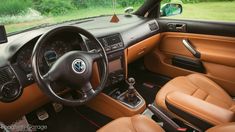 the interior of a car with brown leather seats and steering wheel, dash board and dashboard