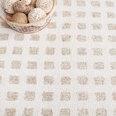 a basket filled with balls of yarn sitting on top of a floor next to a rug