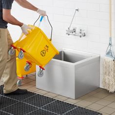 a man is cleaning the floor with a yellow bucket