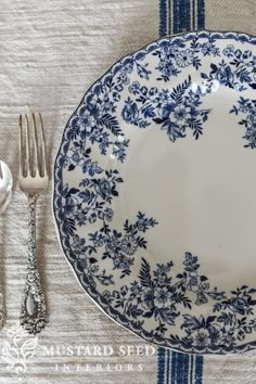 a blue and white plate sitting on top of a table next to utensils