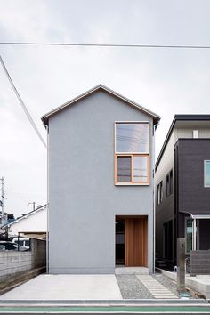 the house is grey and has two windows on one side, and an open door on the other