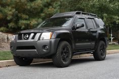 a black nissan truck parked on the side of the road