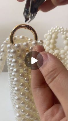 someone is cutting pearls with a pair of scissors on top of the bead bag