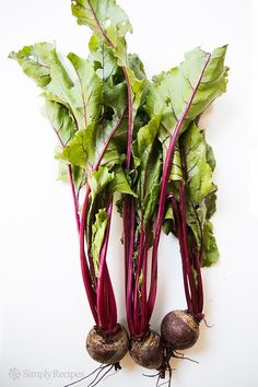 three beets and two turnips on a white surface