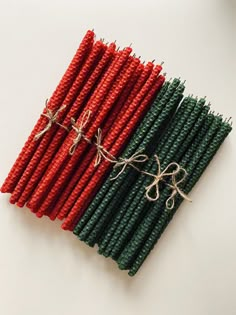 red, green and white straws with twine on them sitting next to each other