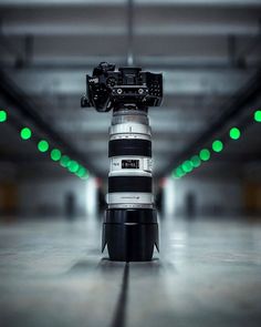 a large camera sitting on top of a tripod in a parking garage with green lights