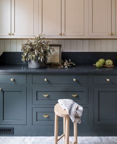 an image of a kitchen setting with blue cabinets and stools in the foreground