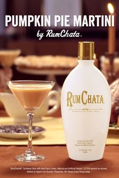 a bottle of rumchata next to a martini glass on a table with food