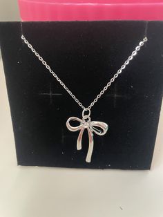 A beautiful bow necklace on an 40cm silver stainless steel chain size of bow is 2cm x 2.6 cm gold colour alloy charm Adjustable Silver Necklace For Gift, Silver Charm Necklace In Alloy, Silver Charm Necklace With Delicate Chain For Party, Silver Delicate Chain Charm Necklace For Party, Sterling Silver Necklace With Delicate Chain For Party, Silver Necklace With Adjustable Chain As Gift For Her, Dainty Sterling Silver Necklace For Party, Dainty Silver Necklace For Party, Sterling Silver Charm Necklace With Delicate Chain For Party