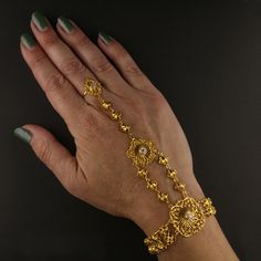 Description: This striking vintage slave bracelet is crafted from luxurious 21K yellow gold and weighs an impressive 24 grams. Adorned with dazzling cubic zirconia stones, this piece exudes elegance and sophistication. Perfect for those who appreciate bold, vintage designs, this bracelet makes a beautiful statement of timeless style and luxury. Specifications: Metal: 21K Yellow Gold Weight: 24 grams Gemstones: Cubic Zirconia (CZ) Style: Vintage slave bracelet Item Code: Meta Description (150 cha Groom Accessories, Cz Bracelet, Bridal Bands, Chain Earrings, Timeless Style, Bracelet Making, Chains Necklace, Style Vintage, Bridal Jewelry