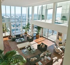 a living room filled with lots of furniture and tall windows overlooking the cityscape