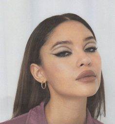 a close up of a person with long hair and wearing earrings on her head, against a white background