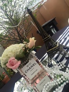 a chanel bottle with flowers in front of the eiffel tower on display