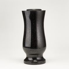 a black vase sitting on top of a white table