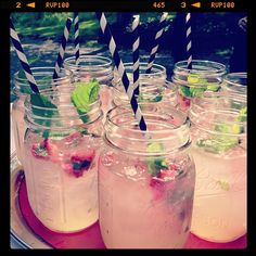 several mason jars filled with drinks and drinking straws