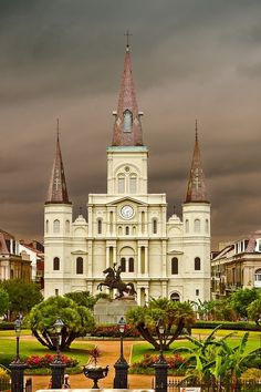 a large white building with a clock on it's face and two spires