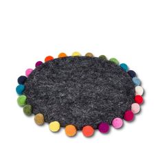 a round rug with multi colored pom poms