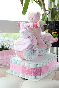 a pink teddy bear sitting on top of a pile of diapers