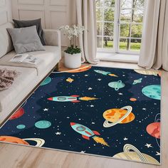 an area rug with space and planets on it in a living room next to a couch