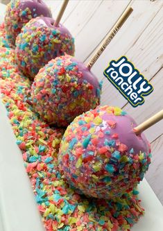 cake pops with sprinkles are on a white plate and there is a stick sticking out of it