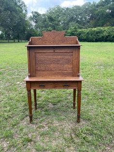 an old wooden desk sitting in the middle of a field