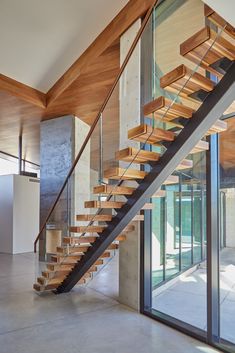 a wooden staircase with glass balconies in a modern home