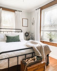 a bedroom with white walls and wood floors