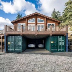 two cars are parked in front of a house with shipping containers attached to the garage