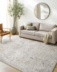 a living room with a couch, chair and mirror on the wall next to a potted plant