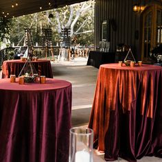 two round tables covered with red tablecloths