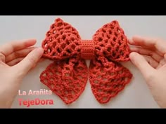 crocheted bow with two hands holding it up to show the pattern on top