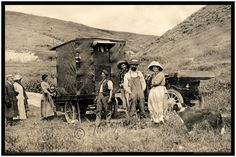 an old black and white photo of people standing in front of a horse drawn carriage