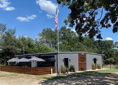 a building with an american flag on top of it and some trees in the background