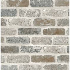 a brick wall with grey and white bricks