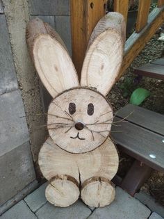 a wooden bunny sitting next to a bench