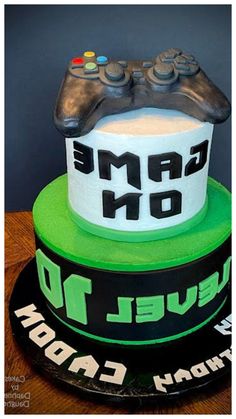 a birthday cake with a video game controller on top and the words game on below it