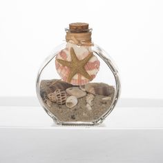 a glass bottle filled with sand and shells