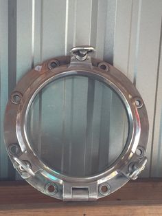 a metal porthole on top of a wooden shelf