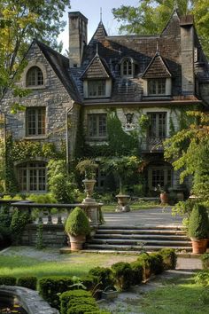 a large stone house with many windows and steps leading to the front door, surrounded by greenery