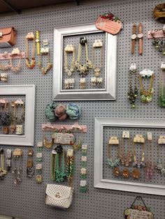 there are many necklaces hanging on the wall next to pictures and purses in frames