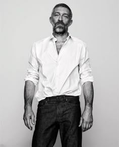 a black and white photo of a man with a beard in a button up shirt