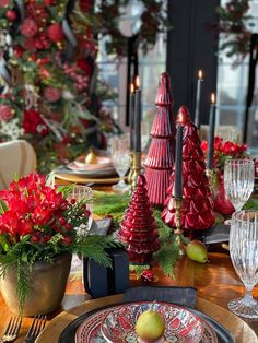 a table set for christmas with red and green decorations