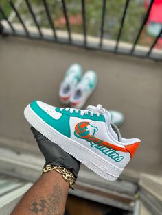 Custom Miami Dolphin Themed Air Force 1s. This price includes purchasing the sneakers. All Adult sizes are for both Men and Women. All prices are USD. Color Shade of shoe may vary on screen versus in person and under different lighting. All shoes are Made to Order and turnaround for completion is 4-6 weeks per shoe. Air Force One Shoes, Custom Nike Air Force, Dolphins Football, Custom Shoes Diy, Nike Shoes Air Force, Nike Air Force 1s, Painted Sneakers, Air Force 1s, Custom Nike Shoes