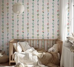 a bedroom with floral wallpaper and bedding in the foreground is a radiator